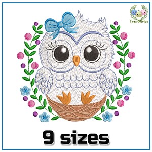Puede incluir: Diseño bordado de un búho blanco con un lazo azul, sentado en un nido rodeado de una corona de hojas verdes y flores rosas, moradas y azules. El diseño está disponible en 9 tamaños.