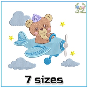 Könnte beinhalten: Stickdatei mit einem braunen Teddybär, der einen blauen Hut trägt und ein blaues Flugzeug mit gelben Sternen und Wolken fliegt. Das Design ist in 7 Größen erhältlich.