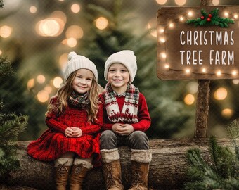 May include: Two children wearing white knitted hats and winter clothing sit on a log in front of a sign that reads "Christmas Tree Farm". The sign is decorated with fairy lights and a sprig of greenery.
