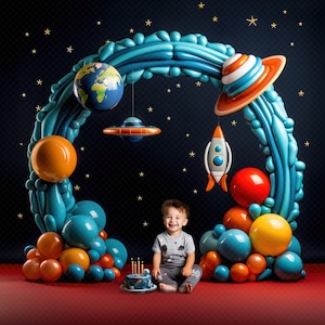 May include: A child sits in front of a balloon archway decorated with planets, a rocket, and stars. The archway is made of blue, orange, and yellow balloons. The child is holding a birthday cake with candles.