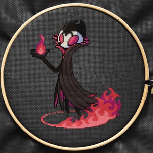 May include: Cross-stitch embroidery of a black and red character with a cape and a flame in their hand, standing on a red flame base.