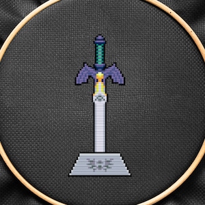 May include: A purple and green pixelated sword with a white handle and a gray base. The base has the word "TRI FORCE" written on it.