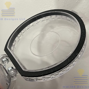 May include: A clear plastic box with a black rubber seal around the edge. The lid is open and the box is empty.