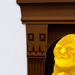 May include: A brown wooden frame with a decorative design surrounds a yellow illuminated bust of a man with a serious expression. The frame has a fluted column on the left side and a decorative arch on the right side.