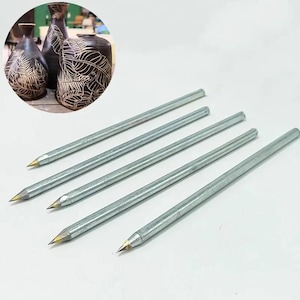 Op de afbeelding: Vijf zilveren metalen gereedschappen met puntige uiteinden. De gereedschappen worden gebruikt voor het snijden en decoreren van aardewerk. De gereedschappen worden getoond tegen een witte achtergrond.