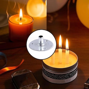 May include: An orange candle in a glass container with a lit wick. A metal candle holder is in the center. A small candle tin with three lit candles is on the right. A lighter is on the bottom left.