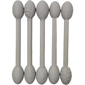 May include: Five light gray double-ended tools arranged vertically. Each tool features a long, smooth cylindrical handle with an oval-shaped head at both ends. The heads display varied, raised, organic textures, including pebbled and brain-like patterns.