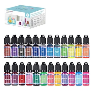 May include: A selection of liquid colourants in small dropper bottles, labelled with various colours such as Garnet, Violet, and Blue. The bottles are arranged in rows, with a box in the background that reads "COLORANT" and "USED FOR SOAP BASE/ CANDLE/ MOLD SILICONE COLORING."