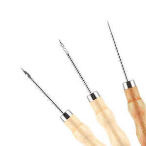 May include: Three leather sewing awls with wooden handles. The awls have a sharp, pointed tip and are used for piercing holes in leather.