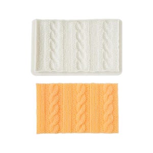 May include: Two silicone molds, one white and one orange, each with a cable knit pattern. The molds are rectangular with a raised, textured design. The white mold is in a rectangular frame. The orange mold is a solid rectangle.
