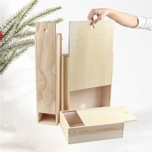 Puede incluir: Tres cajas de madera con tapas. Las cajas son de madera natural y tienen un diseño sencillo. Las cajas están apiladas una encima de la otra.