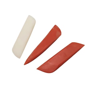 May include: Three elongated, wedge-shaped tools for smoothing or creasing. One tool is off-white with a rounded edge, while the other two are a solid terracotta red color, featuring pointed ends and angled, flat surfaces for precise manual work.