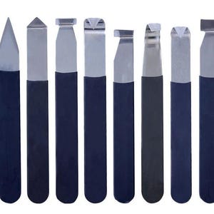 May include: A set of eight metal sculpting tools with dark blue handles. Each tool features a distinct silver-colored metal tip, including pointed, flat, notched, and hooked shapes, designed for precision work in clay or other malleable materials.
