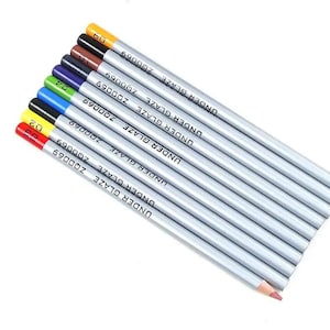 Puede incluir: Un juego de ocho lápices para bajo esmalte con cuerpos plateados, cada uno con una punta de color y el texto impreso UNDER GLAZE ZQ0069. Los lápices muestran una variedad de colores de pigmento que incluyen rojo, amarillo, negro, azul, verde, morado, marrón y naranja.