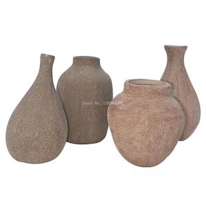 May include: Four textured ceramic vases in various shapes and sizes. The vases are a light brown color with a rough, sandy texture.