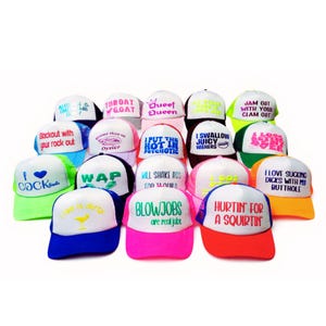 Puede incluir: Una colección de gorras de camionero con varias frases y gráficos. Las gorras tienen la parte trasera de malla y viseras curvas, con textos como "Throat Goat", "Blowjobs are real jobs" y "I love sucking dicks with my butthole".