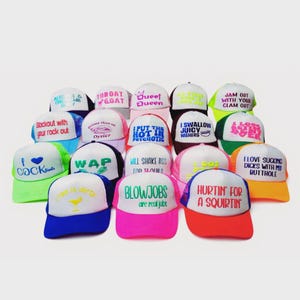 May include: A collection of multi-colored trucker hats featuring various embroidered phrases and graphics on the white front panels. The hats include neon and primary colors with mesh backs and adjustable snapback closures, displaying diverse text.