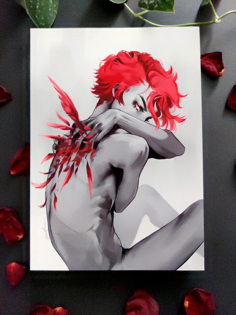 May include: A grayscale art print depicting a figure with striking red hair and red feather details on the back. The figure is seated, arms crossed. Red rose petals are scattered around the print, creating a dramatic effect.