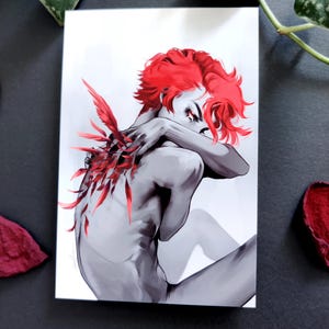 May include: Grayscale art print showing a figure with vibrant red hair and feather-like details. The figure is in a seated position, arms wrapped around the body. The artwork has a dramatic and artistic style.