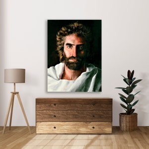 Puede incluir: Una pintura de un hombre con barba y pelo largo, vestido con una t&uacute;nica blanca. El hombre mira directamente al espectador con una expresi&oacute;n seria. El fondo es oscuro.