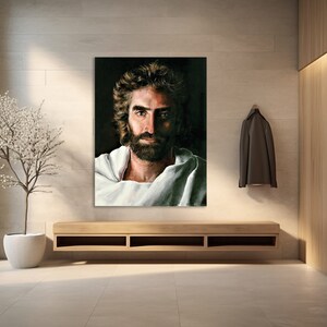 Puede incluir: Una pintura de un hombre con barba y pelo largo, vistiendo una t&uacute;nica blanca. La pintura est&aacute; sobre un fondo oscuro.