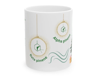 May include: White ceramic mug with a green Christmas tree design. The tree has two ornaments with gold glitter and green 3D molecular structures. The text "Alpha pinene" and "Beta pinene" is written on the mug.