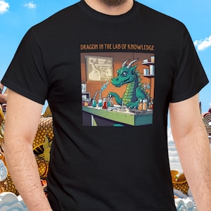 May include: A black t-shirt with a green dragon wearing a lab coat and holding a beaker. The text "DRAGON IN THE LAB OF KNOWLEDGE" is printed above the image.
