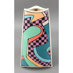May include: A white ceramic vase with a geometric design in shades of teal, pink, orange, and black. The vase has a square base and a slightly flared top.