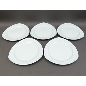 May include: Five white, oval-shaped plates with a unique, asymmetrical design. Each plate has a slightly raised rim and a smooth, glossy surface. The plates are arranged on a dark gray background, showcasing their clean, modern aesthetic. Ideal for serving appetizers or desserts.