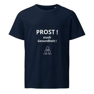 Peut inclure: T-shirt bleu marine avec l'inscription blanche "PROST! euuh Gesundheit!" en allemand, accompagnée d'un petit dessin de bonhomme. Un vêtement simple et décontracté.