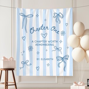 May include: A light blue and white striped backdrop with the text "Chapter One" and "A Chapter Worth Remembering" in blue. The backdrop is decorated with blue bows, hearts, flowers, and stars. A cluster of white balloons is on the right.