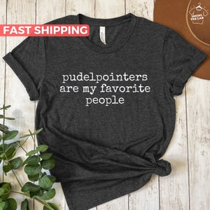 May include: A dark grey t-shirt with the text "pudelpointers are my favorite people" printed in white.