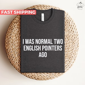 May include: Dark grey t-shirt with the text "I was normal two English pointers ago" printed in white.