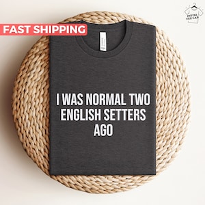 May include: Dark gray t-shirt with the text "I was normal two English Setters ago" printed in white.