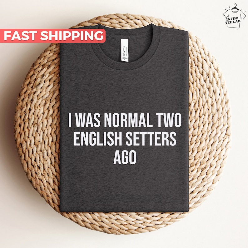 May include: Dark gray t-shirt with the text "I was normal two English Setters ago" printed in white.