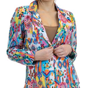 May include: A colorful blazer with a vibrant, abstract pattern in shades of pink, yellow, blue, and orange. The blazer has a classic lapel and button closure. The fabric appears to be lightweight.