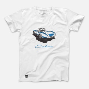 May include: White t-shirt with a blue and white illustration of a classic Cobra sports car and the word "Cobra" in blue script.