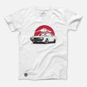 May include: White t-shirt with a black and white illustration of a classic car in front of a red sun and mountain silhouette.