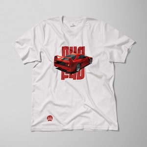May include: White t-shirt with a red Ferrari F40 printed on the front. The car is facing away from the viewer and the text "F40" is printed in red letters.