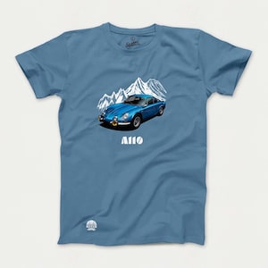 May include: A blue t-shirt with a white graphic of a blue car driving through a mountain range. The text "A110" is printed below the car.
