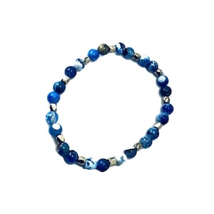 May include: A circular beaded bracelet featuring alternating round blue agate beads with white marbling and small, faceted metallic silver-toned spacer beads. The beads are strung together in a continuous loop, showcasing a variety of blue shades.