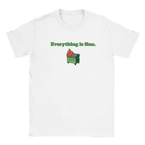 Puede incluir: Camiseta blanca con la frase "Everything is fine" en texto verde. Debajo del texto hay una imagen de dibujos animados de un contenedor de basura verde en llamas. La camiseta es de cuello redondo.