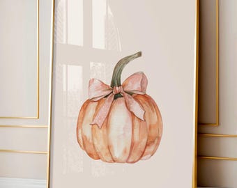Puede incluir: Pintura a la acuarela de una calabaza con un lazo rosa con lunares. La calabaza es naranja con rayas verticales, y el lazo está atado alrededor del tallo verde. La obra de arte está enmarcada en un marco dorado, ideal para la decoración de otoño.