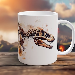 Peut inclure: Une tasse en céramique blanche avec une image de squelette de Tyrannosaurus Rex de style aquarelle. Le dinosaure est brun et blanc et fait face à droite. L'arrière-plan est brun clair avec des éclaboussures blanches.
