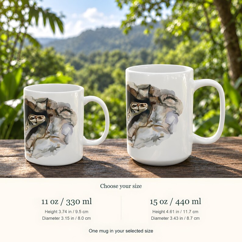 Puede incluir: Dos tazas de cer&aacute;mica blanca con una ilustraci&oacute;n en acuarela de una serpiente asom&aacute;ndose por una grieta rocosa. La taza peque&ntilde;a es de 330 ml con 9,5 cm de altura, y la grande es de 440 ml con 11,7 cm de altura.