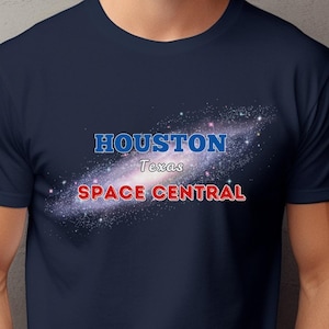 May include: A navy blue t-shirt with a galaxy graphic and the text "HOUSTON Texas SPACE CENTRAL" printed on the front.
