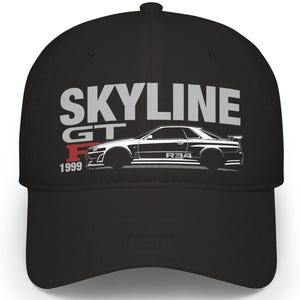 Puede incluir: Gorra de béisbol negra con el texto "SKYLINE GT" en blanco y "F 1999" en rojo. Un gráfico blanco de un coche está debajo del texto. La gorra tiene una visera curva y una corona estructurada.