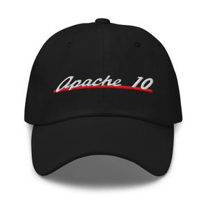 Op de afbeelding: Zwarte baseballcap met de geborduurde tekst "Apache 10" in wit en rood. De pet heeft een gebogen klep en een ontwerp met zes panelen. De pet is gemaakt van een zachte, duurzame stof.