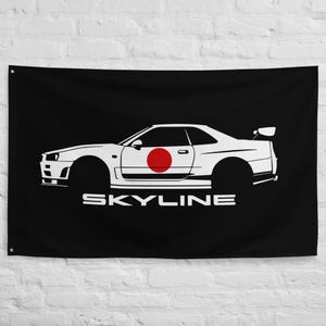 Puede incluir: Bandera negra con el contorno blanco de un coche deportivo, que incorpora un círculo rojo que representa la bandera japonesa. La palabra "SKYLINE" está impresa en blanco debajo.