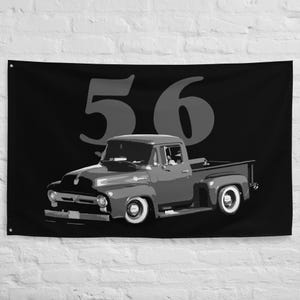 May include: Black and white wall flag featuring a classic vintage pickup truck. The truck is in grayscale, with white-walled tires and a detailed design. The number "56" is displayed in large, gray numerals above the truck.